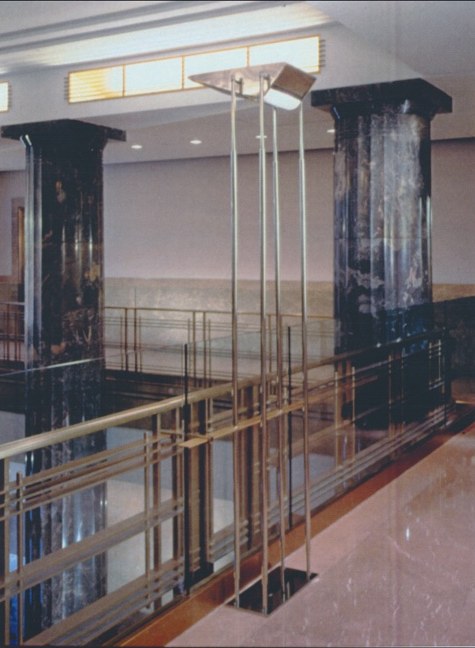 Marble lobby with a custom stainless light fixture.